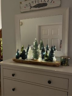 a white dresser with christmas trees on it