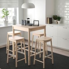 a kitchen table with three stools in front of it