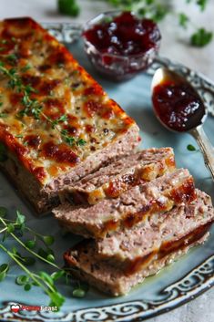 sliced meatloaf on a plate with sauces and herbs