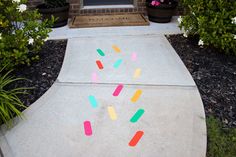 the sidewalk is decorated with colorful stickers and flower potted trees in the background