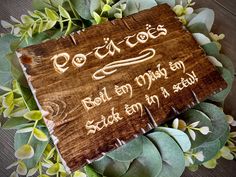 a wooden sign sitting on top of green plants