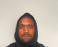 a man in a black hoodie is looking at the camera