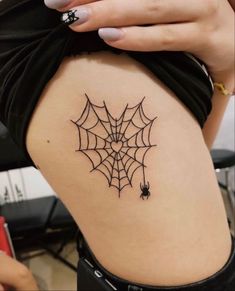 a woman with a spider web tattoo on her thigh