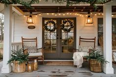 the front porch is decorated for christmas with wreaths, lights and wicker chairs