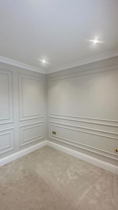 an empty room with white walls and beige carpet