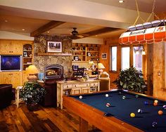 a living room with a pool table and fireplace