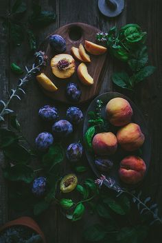 there are plums, peaches and blueberries on the table