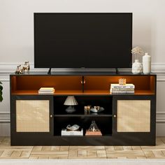 a flat screen tv sitting on top of a wooden entertainment center with wicker doors