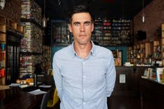 a man standing in front of a bookshelf