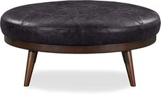 an ottoman with wooden legs and black leather upholstered cushion on the top, in front of a white background