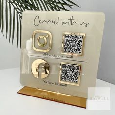 a white and gold plaque with qr - code on it that says connect us