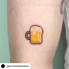 a beer mug tattoo on the right thigh with an orange liquid in it's cup