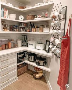 a kitchen with white cabinets and shelves filled with food