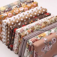 a bunch of different types of fabric on a white tablecloth with flowers and polka dots