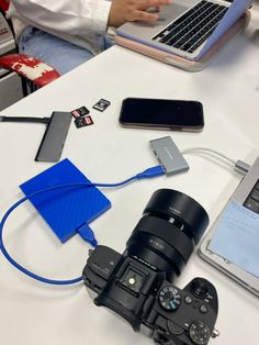 a camera, laptop and other electronics on a table