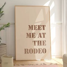 a poster with the words meet me at the rodeo on it next to a potted plant