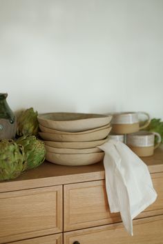 a stack of plates sitting on top of a wooden dresser