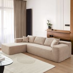 a living room filled with furniture and a white rug on top of a hard wood floor