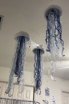 three jellyfishs hanging from the ceiling in a room with other items on it