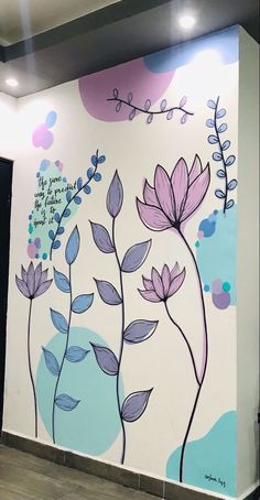 the wall is painted with flowers and leaves in purple, blue, and pink colors