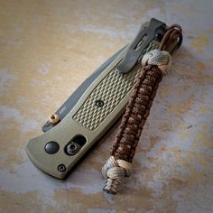 a knife with a cord attached to it sitting on a table next to another knife