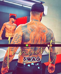 a man with tattoos on his back standing in front of a mirror