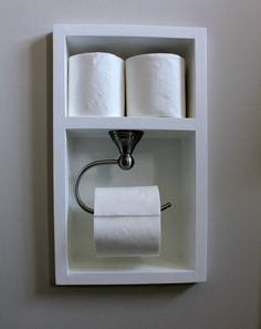 two rolls of toilet paper are hanging on the wall next to a roll of toilet paper