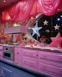 a kitchen with pink cabinets and stars on the wall