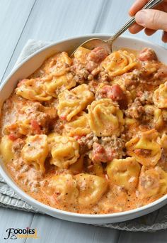 a white bowl filled with pasta and meat