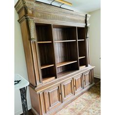 a large wooden bookcase sitting on top of a carpeted floor