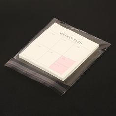 a black table with a white and pink planner on it