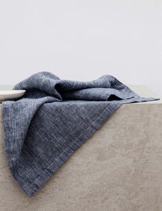 a white plate sitting on top of a table next to a blue towel and bowl