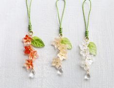 three necklaces with flowers and leaves on them