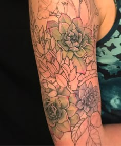 a woman's arm with flowers and leaves tattooed on the side of her body