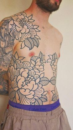 a man with tattoos on his chest and arms