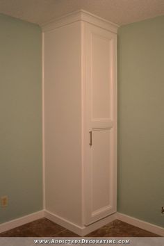 an empty room with a tall white cabinet