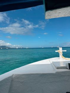 the back end of a boat with water in the background and clouds in the sky