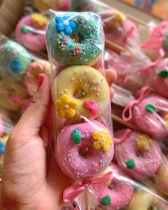 a person holding up some doughnuts with sprinkles and stars on them