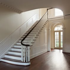 a staircase leading up to the second floor in a home with hardwood floors and white walls