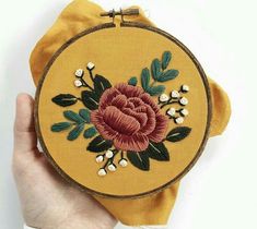 a hand is holding a small embroidered object