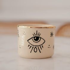 a ceramic cup with an eye drawn on it