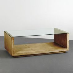 a glass and wood coffee table on a gray floor