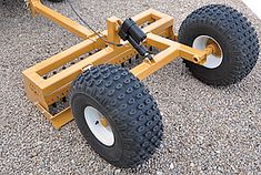 a yellow tow dolly with two large tires