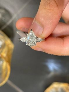 a person holding a diamond ring in their hand