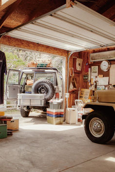 an suv is parked in the garage next to another vehicle and other things on the floor