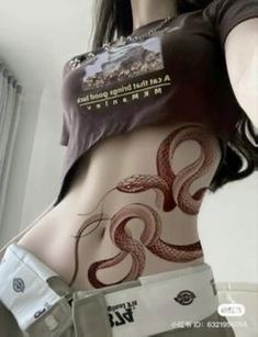 a woman with an octopus tattoo on her stomach is standing in front of a window