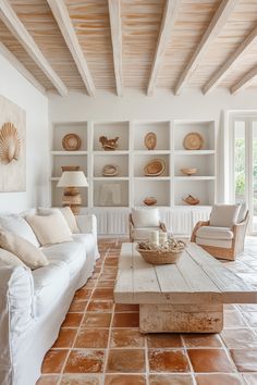 a living room filled with white furniture and lots of shelves