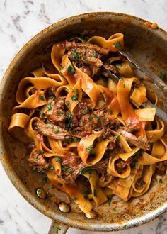 slow cooked shredded beef ragu pasta in a skillet