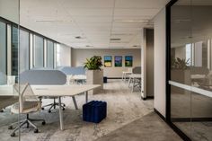 an empty office with glass walls and chairs