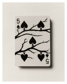 a playing card with hearts and spades on the tree branch in black and white